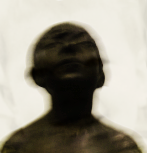 Photo floue et sombre du buste d'un enfant penchant la tête en arrière.