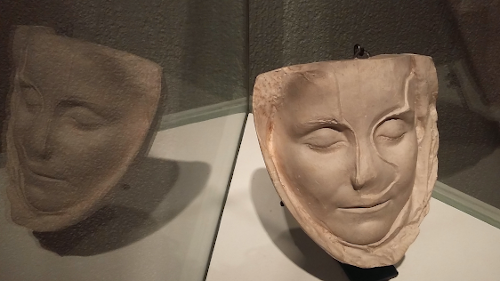 Empreinte du masque mortuaire d'une jeune femme et son reflet dans une vitrine.